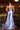 Ladivine Cielo Blue satin gown back view, featuring a lace-up corset back detail, silver beading, and sweeping train.