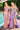 Ladivine dusty rose and lavender satin evening gowns, both featuring structured corset bodices with intricate beading and dramatic high side slits, posed by a swimming pool.