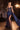 Ladivine navy blue satin evening gown with structured sheer corset bodice, sweetheart neckline, silver crystal beading, dramatic high side slit, and side sash.