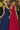 Ladivine one-shoulder chiffon maxi dresses: one in navy blue with a draped bodice, and one in burgundy with a dramatic back sash detail. Ideal formal bridesmaid gowns.
