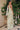 Ladivine sage floral evening gown back view, showcasing the flowing silhouette and draped detachable shoulder scarf, with corset detail visible