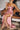 Close-up of Ladivine Dusty Rose Wedding Guest Gown with fitted Corset and Ruching, model seated