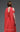 Back view of MNM Couture coral evening gown E0119 with pleated bodice and draped cape detail