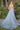 Ladivine light blue tulle ballgown back view, showing sheer corset bodice, embroidered floral details, spaghetti straps, and a sweeping train, modeled outdoors